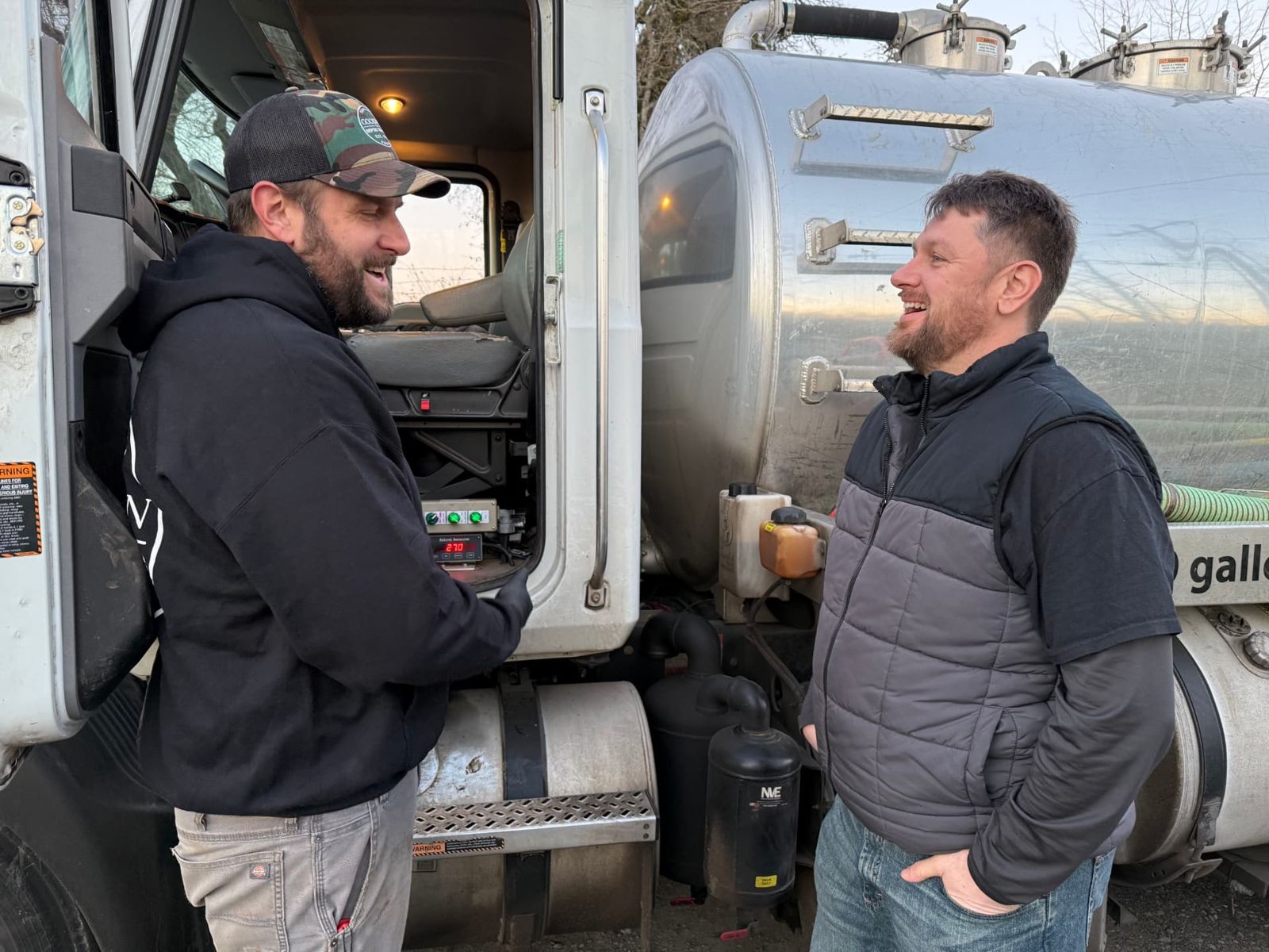 Goodman Septic Services crew talking beside their septic pump truck